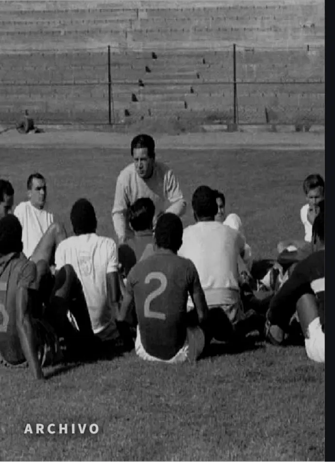 Foto de archivo: un técnico habla a sus jugadores sentados en el césped